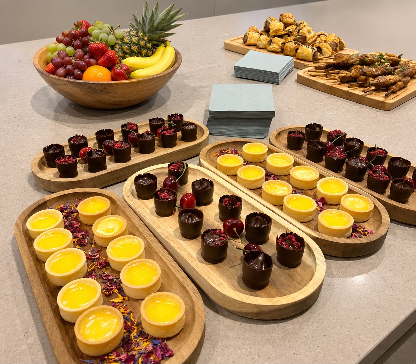 Dessert spread with fruit bowl, tarts and chocolate cups